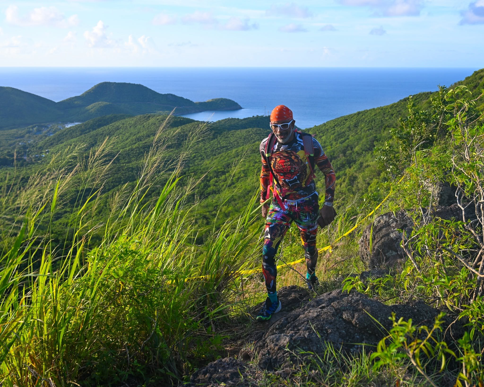 A trail runner climbing through Antigua's green hills