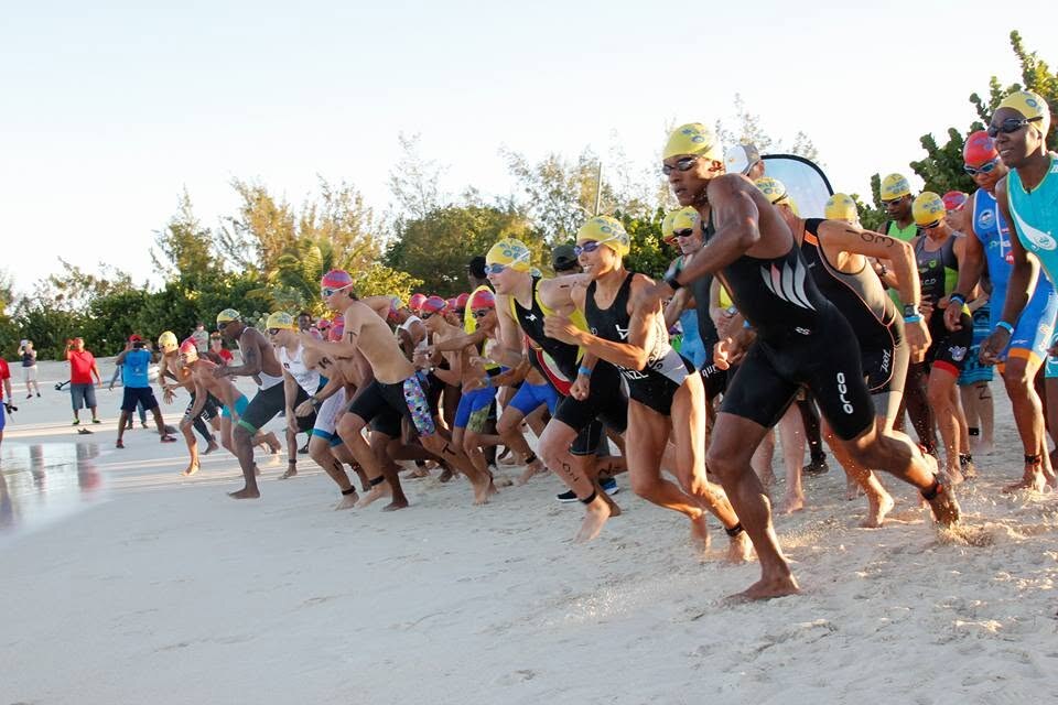 Athletes charging into the water at the AUA Rohrman swim start